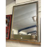 A large modern bevelled wall mirror in distressed finish frame