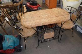 A wicker topped metal garden table and pair of matching chairs