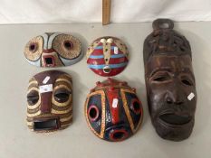 A group of contemporary Congolese pottery wall masks and a further carved wooden mask (5)