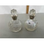 A pair of small cut clear glass and silver collared dressing table bottles