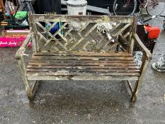 A hardwood garden bench in distressed condition