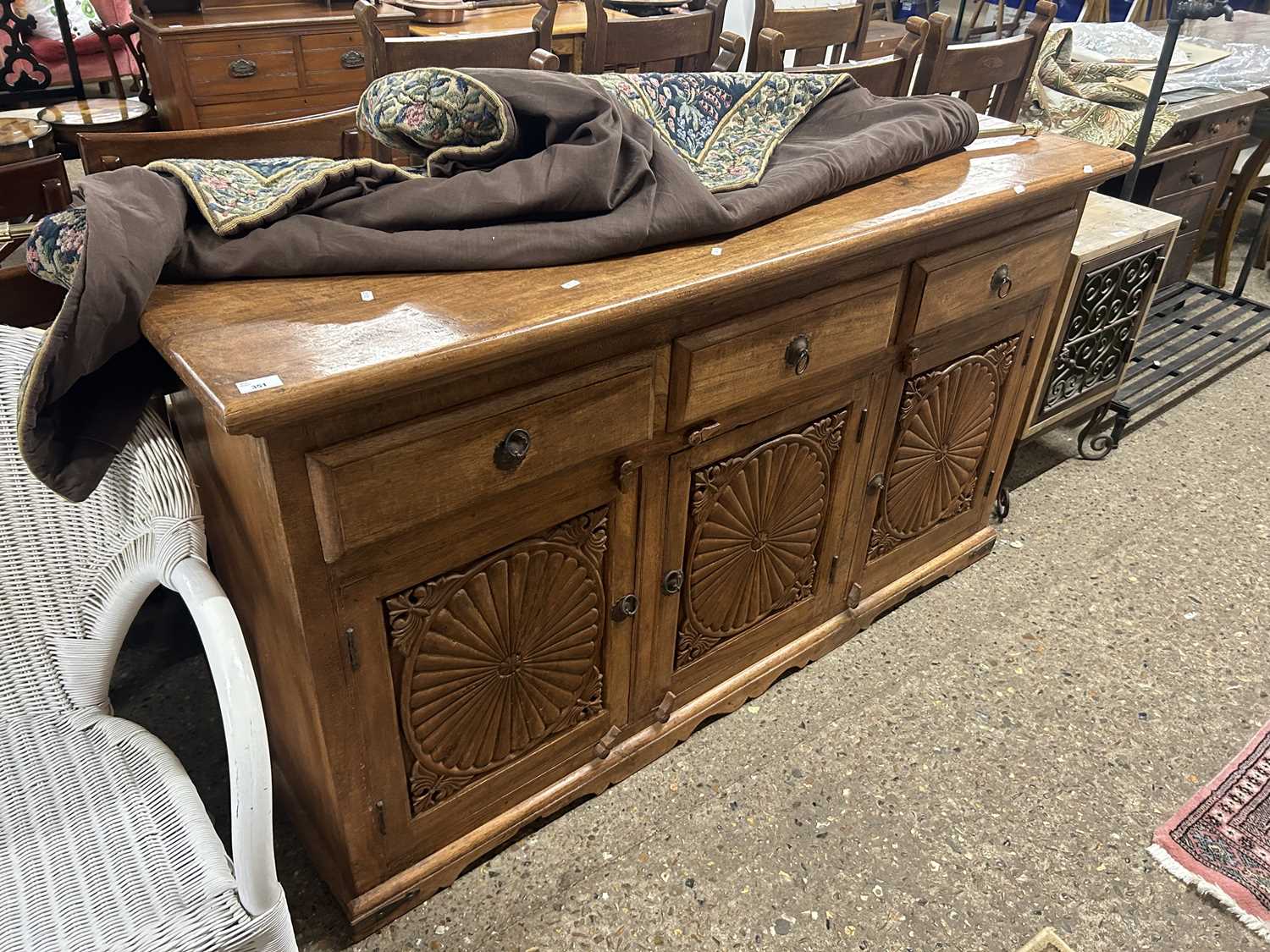 An Indian hardwood three door, three drawer sideboard with carved decoration, 160cm wide