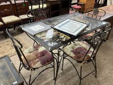 Modern iron framed glass top dining table with floral decoration together with four accompanying