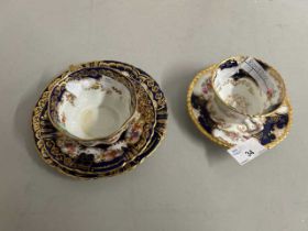 An early 20th Century Coalport cup and saucer, the blue and gilt ground surrounding displays of