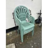 Four plastic stacking garden chairs