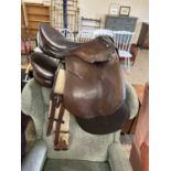 Brown leather saddle and straps and one other (2)