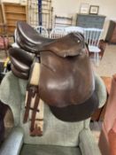 Brown leather saddle and straps and one other (2)