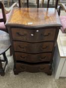 A reproduction serpentine front mahogany four drawer chest