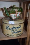 A Brittons Fine Foods Potato Crisps tin and a Chinese teapot