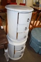 A pair of three drawer round bedside cabinets