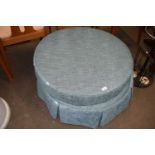A round green upholstered ottoman