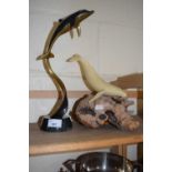 A model of a whale by John Perry, resin on wooden base together with a metal model of a dolphin on