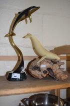 A model of a whale by John Perry, resin on wooden base together with a metal model of a dolphin on