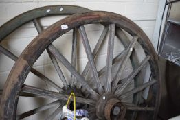 Two large wooden and iron framed cart wheels