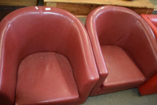 A pair of red faux leather tub chairs