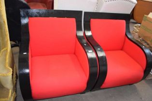 A pair of black painted wooden framed red upholstered armchairs