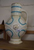 A large cream, blue and gilt decorated jug