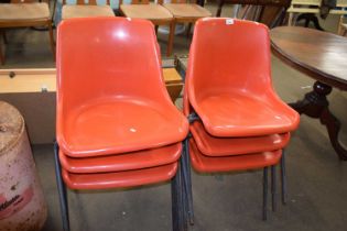 Set of six red plastic stacking chairs