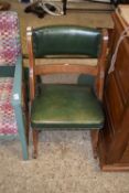 A small green leather upholstered side chair