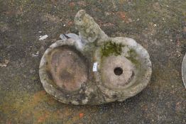 A concrete combination garden planter and bird bath with gnome decoration