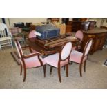 A reproduction mahogany pedestal dining table and six accompanying pink upholstered chairs (7)