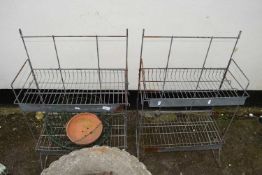 A pair of metal mesh racks together with hanging baskets