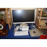 An Apple Mac Mini together with a Philips flat screen keyboad and a wireless mouse