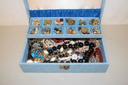 A blue case of various costume jewellery