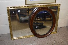 An oval bevelled wall mirror in mahogany finish frame together with a further rectangular wall