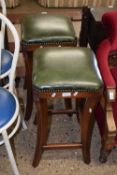A pair of leather upholstered stools