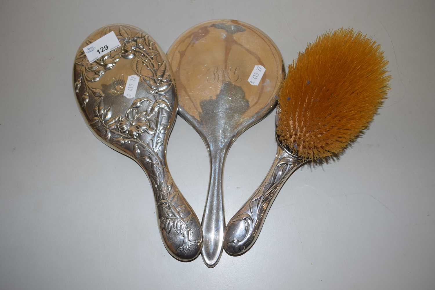 Group of two silver backed dressing table mirrors and an accompanying brush (3)