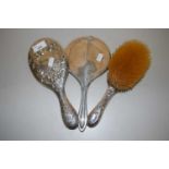 Group of two silver backed dressing table mirrors and an accompanying brush (3)