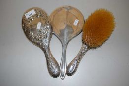 Group of two silver backed dressing table mirrors and an accompanying brush (3)