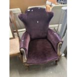 A purple upholstered chair on cabriole legs