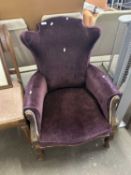 A purple upholstered chair on cabriole legs