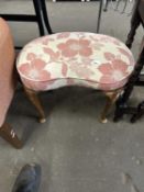 A floral upholstered kidney shaped stool