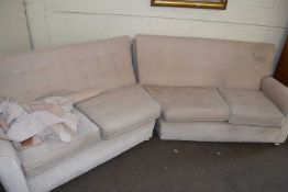 A cream velour angled sofa