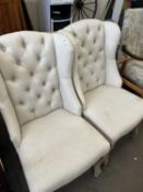 A pair of cream upholstered button backed chairs on cabriole legs