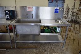 A stainless steel preparation table together with two sinks