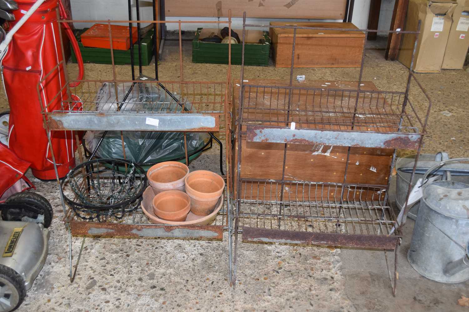 Two metal greenhouse shelves together with some terracotta pots etc