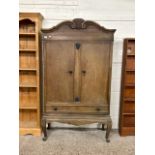 Early 20th Century oak continental two door one drawer cupboard with curved pediument