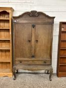Early 20th Century oak continental two door one drawer cupboard with curved pediument