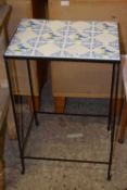 A metal framed tile top table decorated with birds