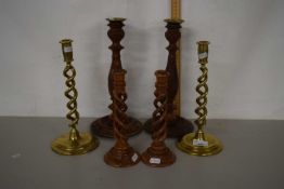 A pair of barley twist brass candlesticks plus two pairs of wooden candlesticks