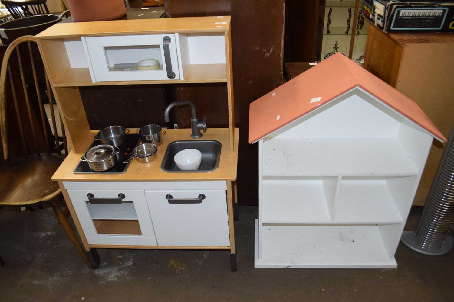 A child's toy kitchen together with a house shaped shelf unit