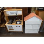 A child's toy kitchen together with a house shaped shelf unit