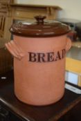 A terracotta bread bin