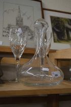 A clear glass decanter and two oversize wine glasses