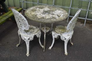 A cast metal garden bistro set consisting of a table and two chairs