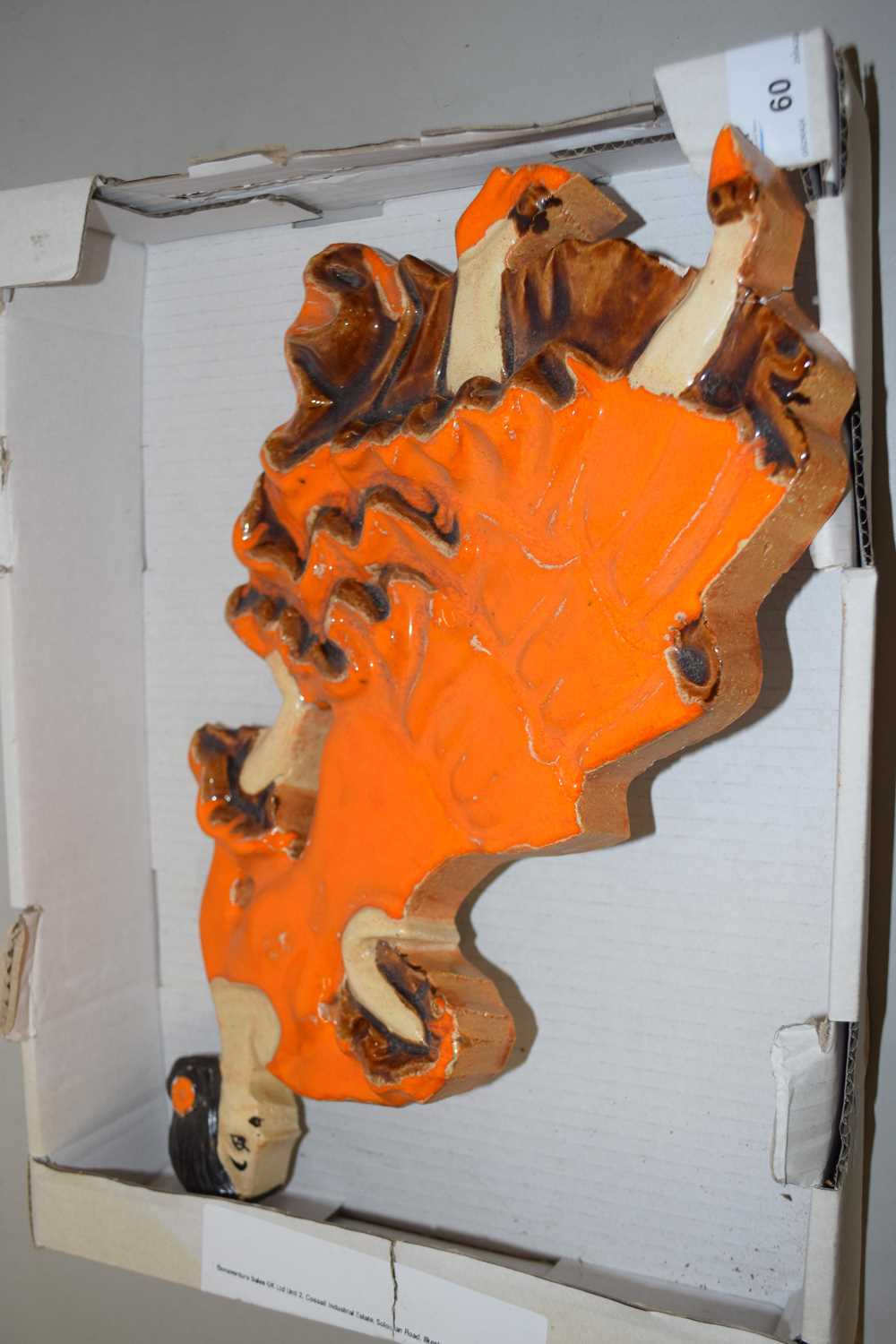 A South African pottery wall plaque formed as a lady in orange dress